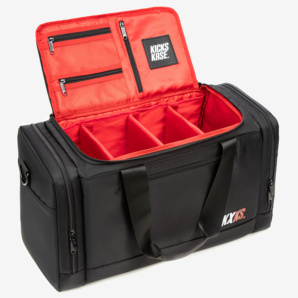 Black and red duffel bag with 'KICKS KASE' branding on a white background